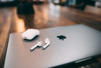 AirPods položené na MacBooku – bezdrátová sluchátka Apple pro snadné připojení k vašim Apple zařízením. Perfektní pro poslech hudby a vyřizování hovorů.